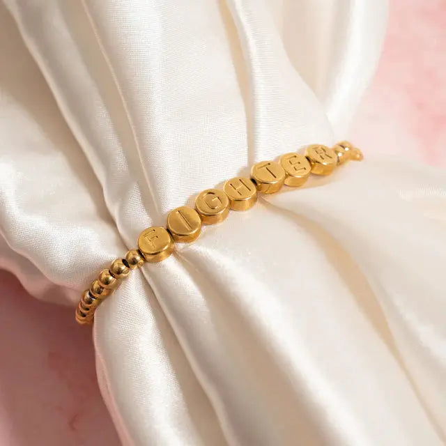 18K gold fighter metal bead bracelet by Winks Design Studio, LLC, featuring round gold beads on a stylish bracelet.