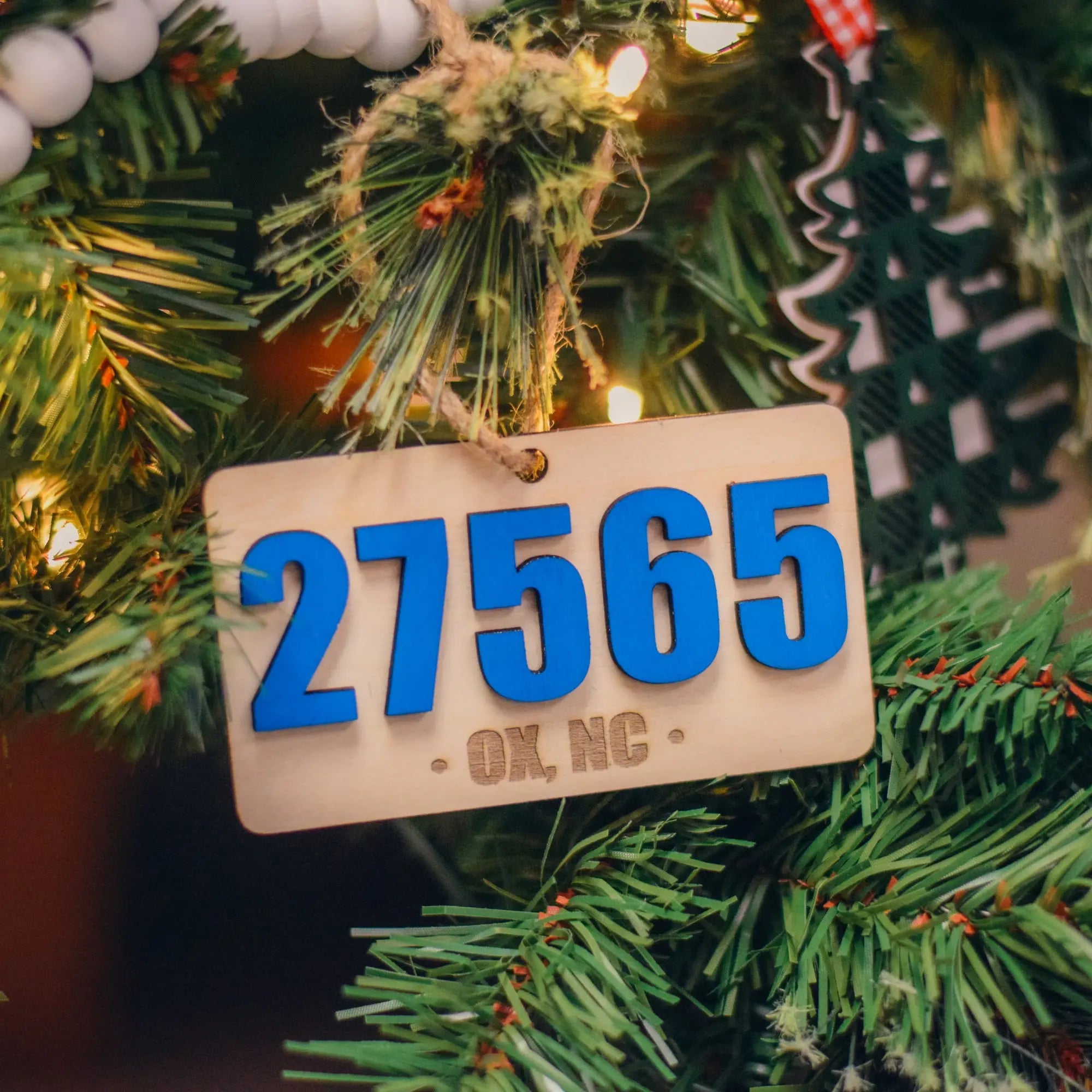 Winks Design Studio LLC Oxford License Plate Ornament featuring a stylish, decorative metal design for car license plates.