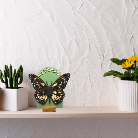 Handcrafted Butterfly Shelf Sign with unique hand-painted design enhancing home decor on a light wooden shelf with plants.