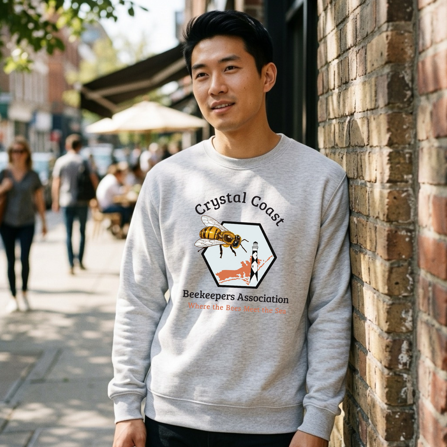 Cream-colored crewneck sweatshirt featuring a Crystal Coast Beekeepers design by Winks Design Studio, LLC, with bee and honeycomb graphics.