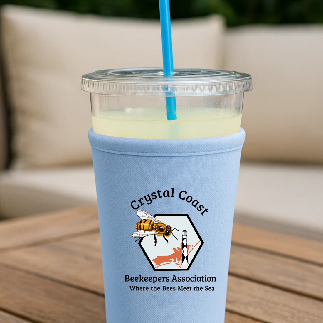 Crystal Coast Beekeepers neoprene cup sleeve with bee and hive design, providing insulation and a snug fit for hot or cold drinks.