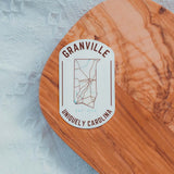 Granville NC map sticker on wooden surface, featuring detailed map outline and text "Uniquely Carolina."