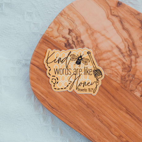 Kind Words Are Like Honey Sticker featuring Proverbs 16:24 Bible verse on a wooden surface