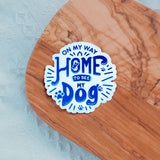 "On My Way Home to See My Dog" vinyl sticker on wooden surface, perfect for dog lovers and indoor or outdoor use.