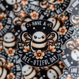 Have A Bee-U-tiful Day sticker with playful bee and flowers design, perfect for spreading positivity and brightening your day.