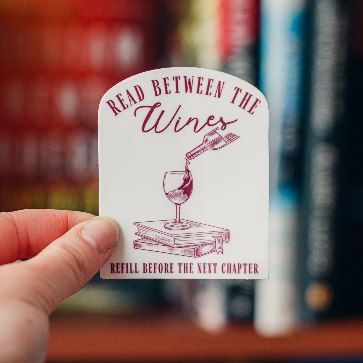 Read Between the Wines sticker by Winks Design Studio, LLC featuring a colorful wine-themed design on a clear adhesive sticker.