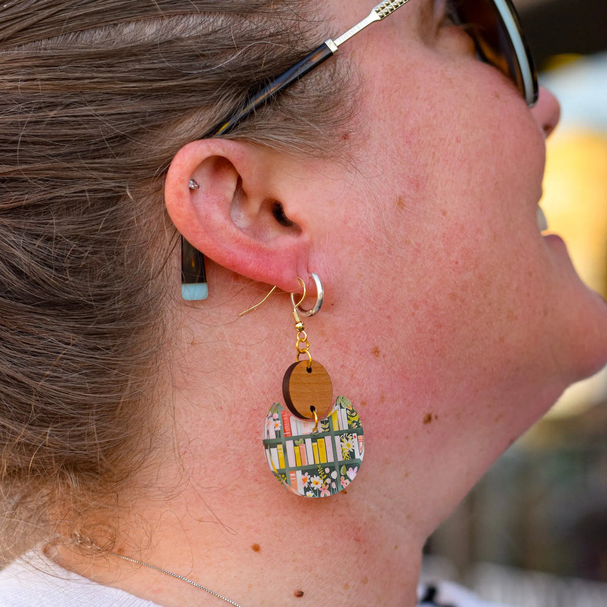 Winks Design Studio LLC bookshelf statement earrings featuring artistic, layered book-shaped designs on silver hooks.
