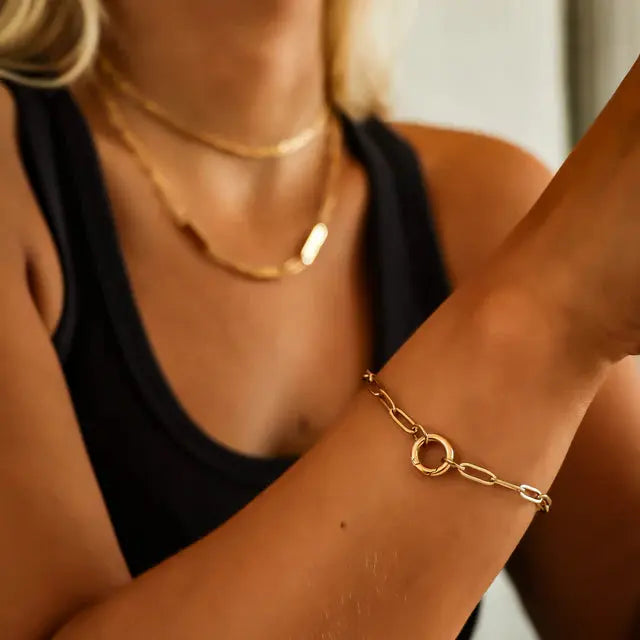 18K gold charm keeper bracelet by Winks Design Studio, LLC showing a close-up of the elegant bracelet with charm details.