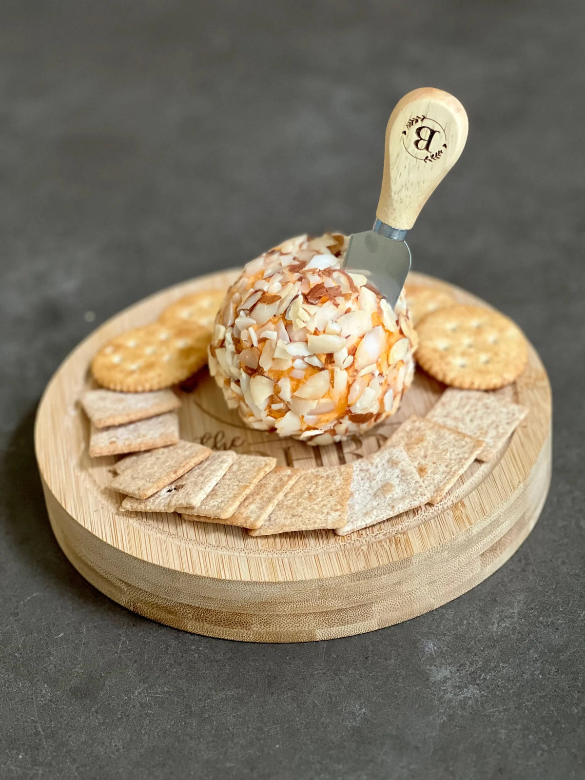Custom genuine bamboo cheese board set with cheese tools, laid out on a wooden table, showcasing the natural grain and elegant design.