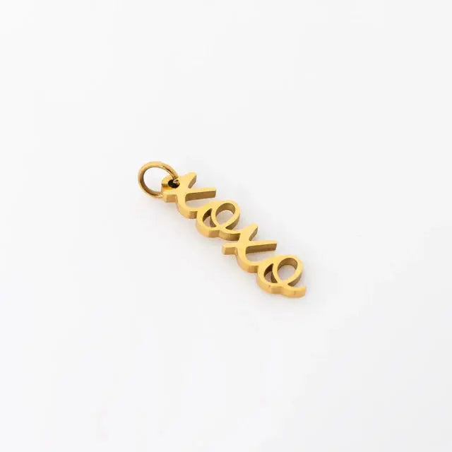 18K gold PVD stainless steel XOXO charm dangle jewelry by Winks Design Studio, LLC, shown in a close-up lifestyle image.