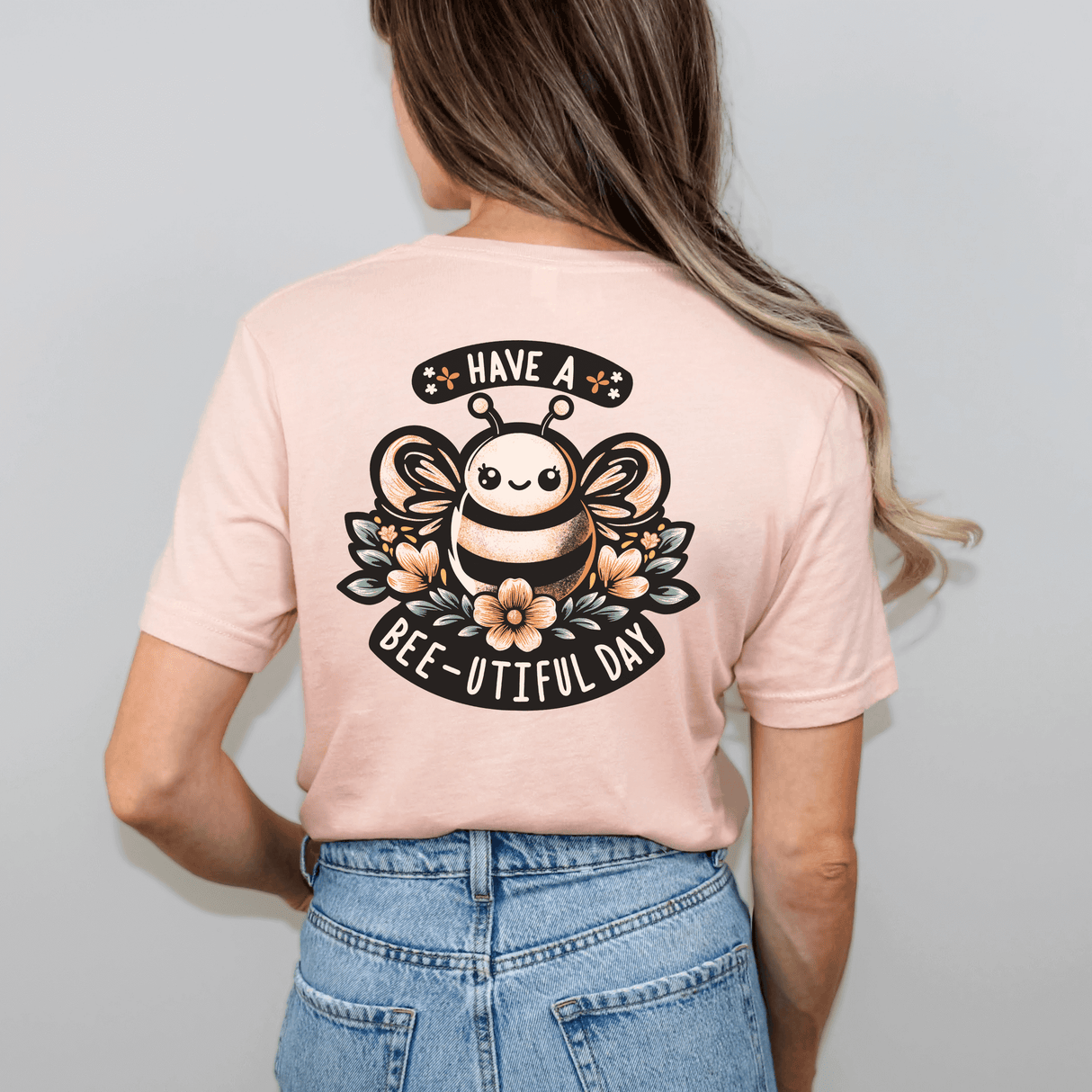 Woman wearing a Bee-utiful Day t-shirt with hand-drawn bee design and flowers, spreading positive vibes.