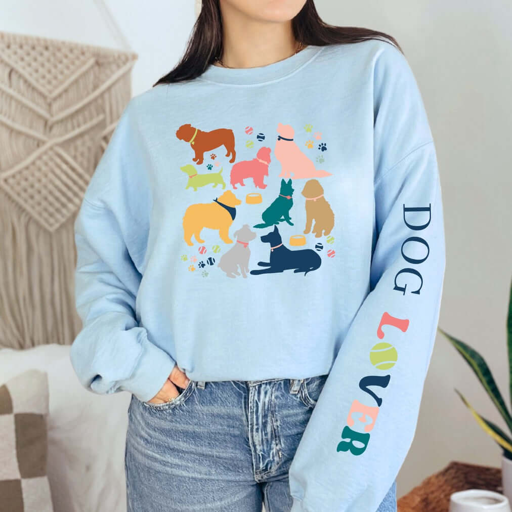 Woman wearing blue Dog Lover Crewneck with colorful dog graphics, perfect for dog owners and animal lovers.