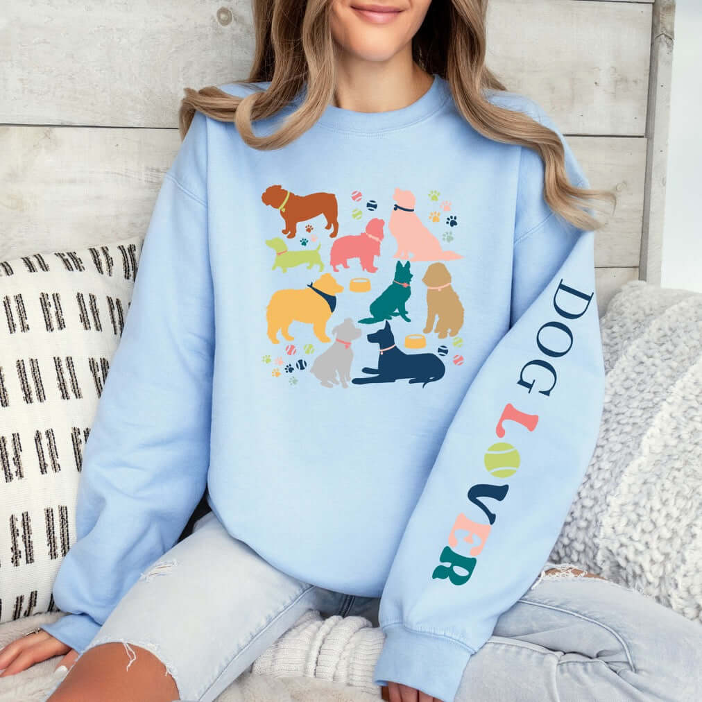 Woman wearing a cozy blue Dog Lover Crewneck with colorful dog illustrations, highlighting love for pets and casual comfort.