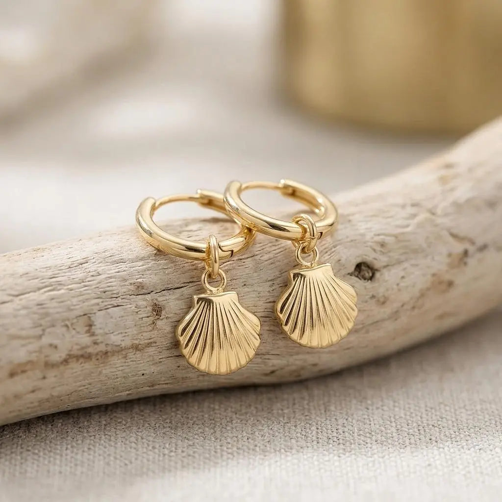 18K gold shell pendant huggie earrings by Winks Design Studio, LLC, featuring elegant gold hoops with shell charms.