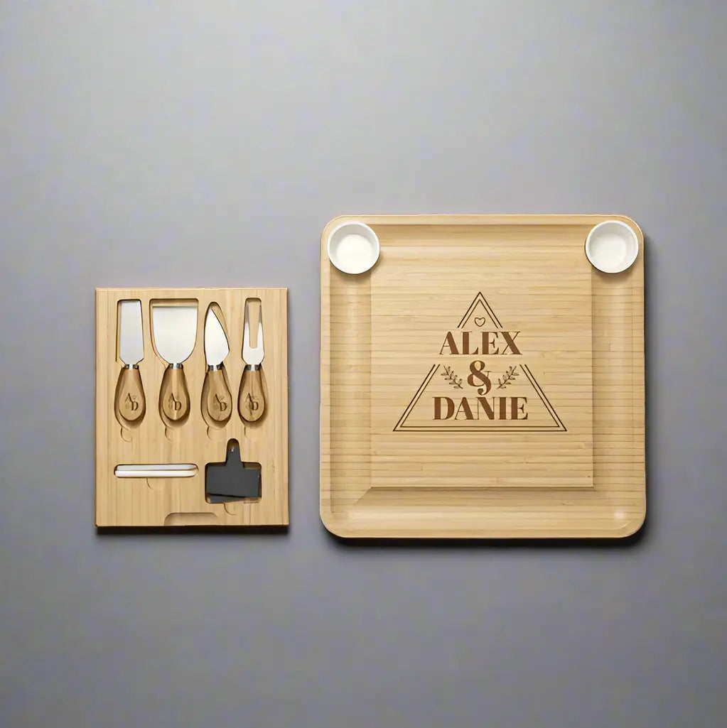Square engraved bamboo cheese board with utensils from Winks Design Studio, LLC, featuring a natural wood finish and serving space.