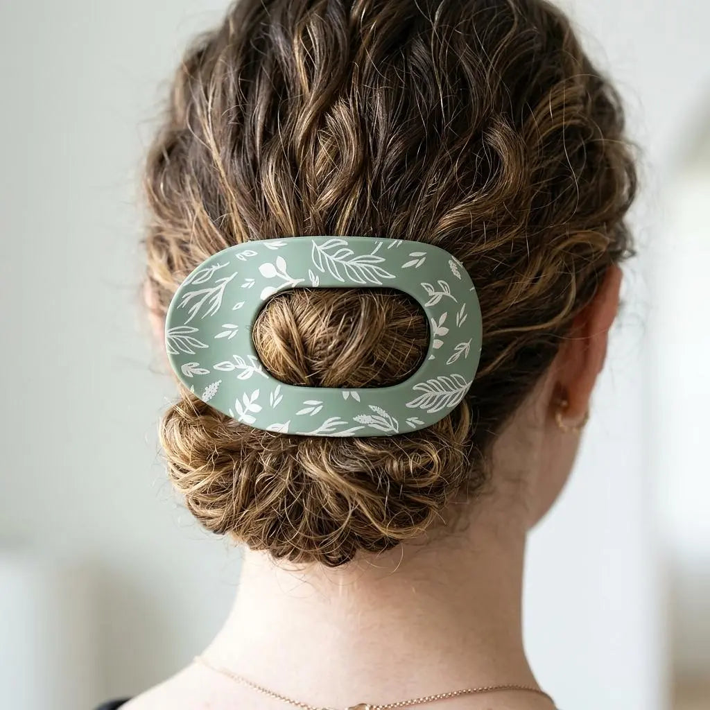 Winks Design Studio LLC sage and stem claw clip holding hair in place, featuring a natural green and stem design.