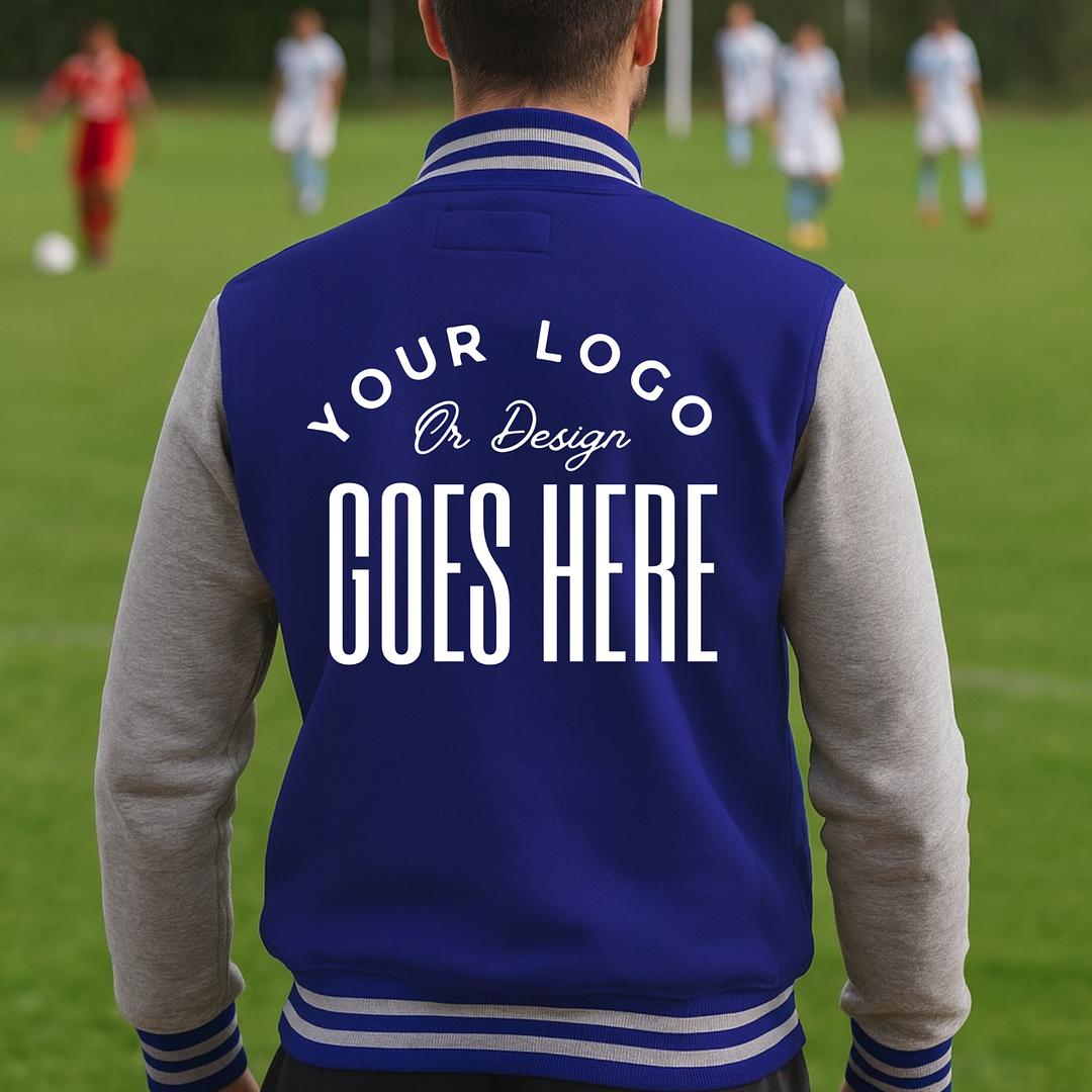 Person wearing a blue varsity jacket with customizable text on a soccer field