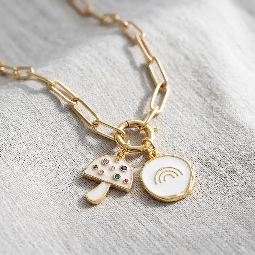 Gold and pearlescent mushroom charm jewelry piece with intricate details, designed by Winks Design Studio, LLC.