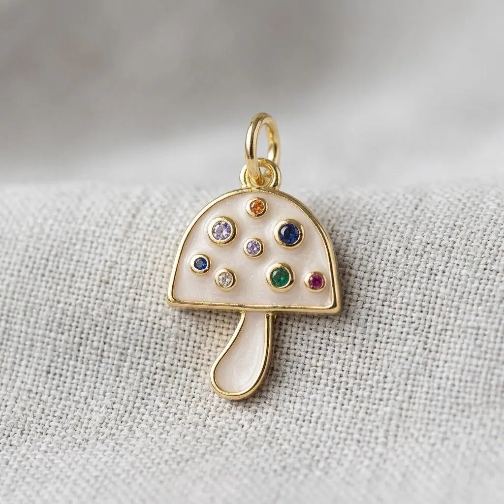 Gold and pearlescent mushroom charm jewelry piece with detailed design from Winks Design Studio, LLC.