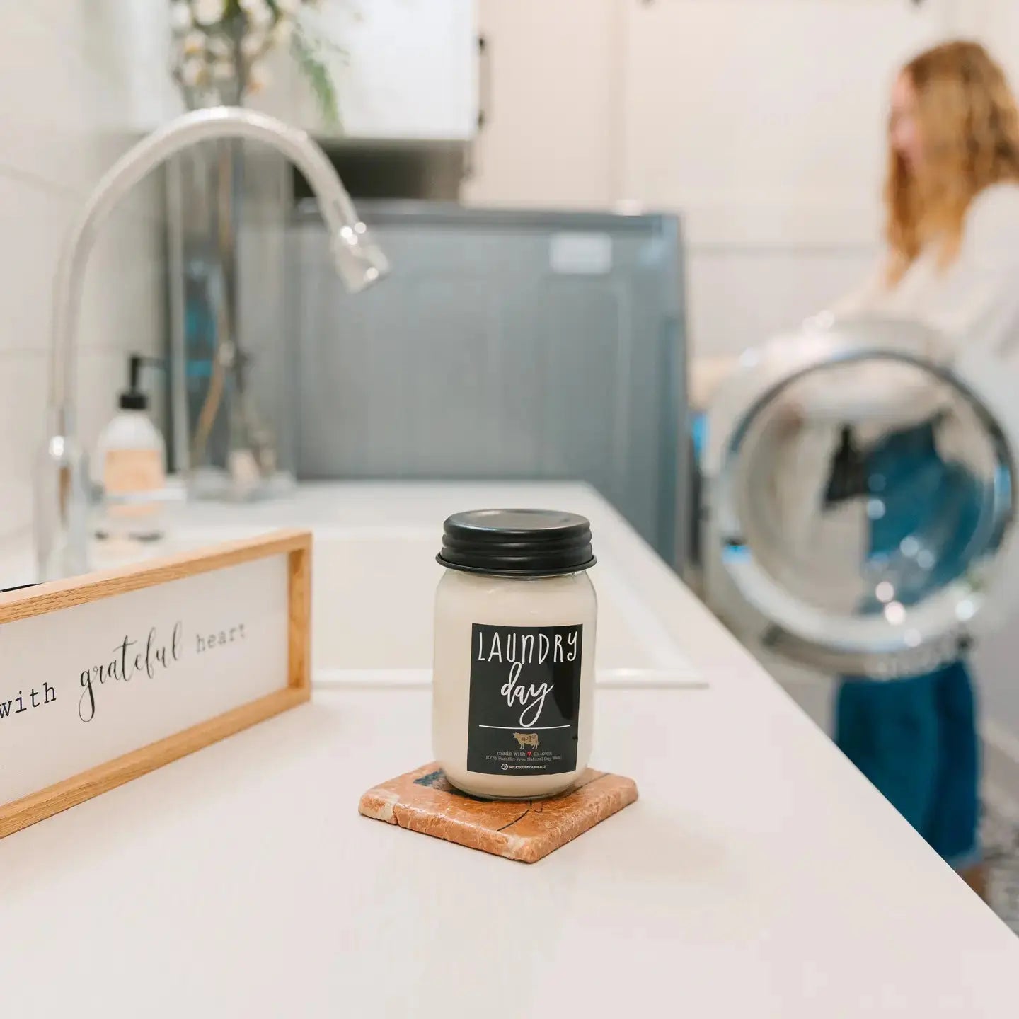 Milkhouse Candle Laundry Day in a 13 oz mason jar by Winks Design Studio with a lit wick and rustic label.