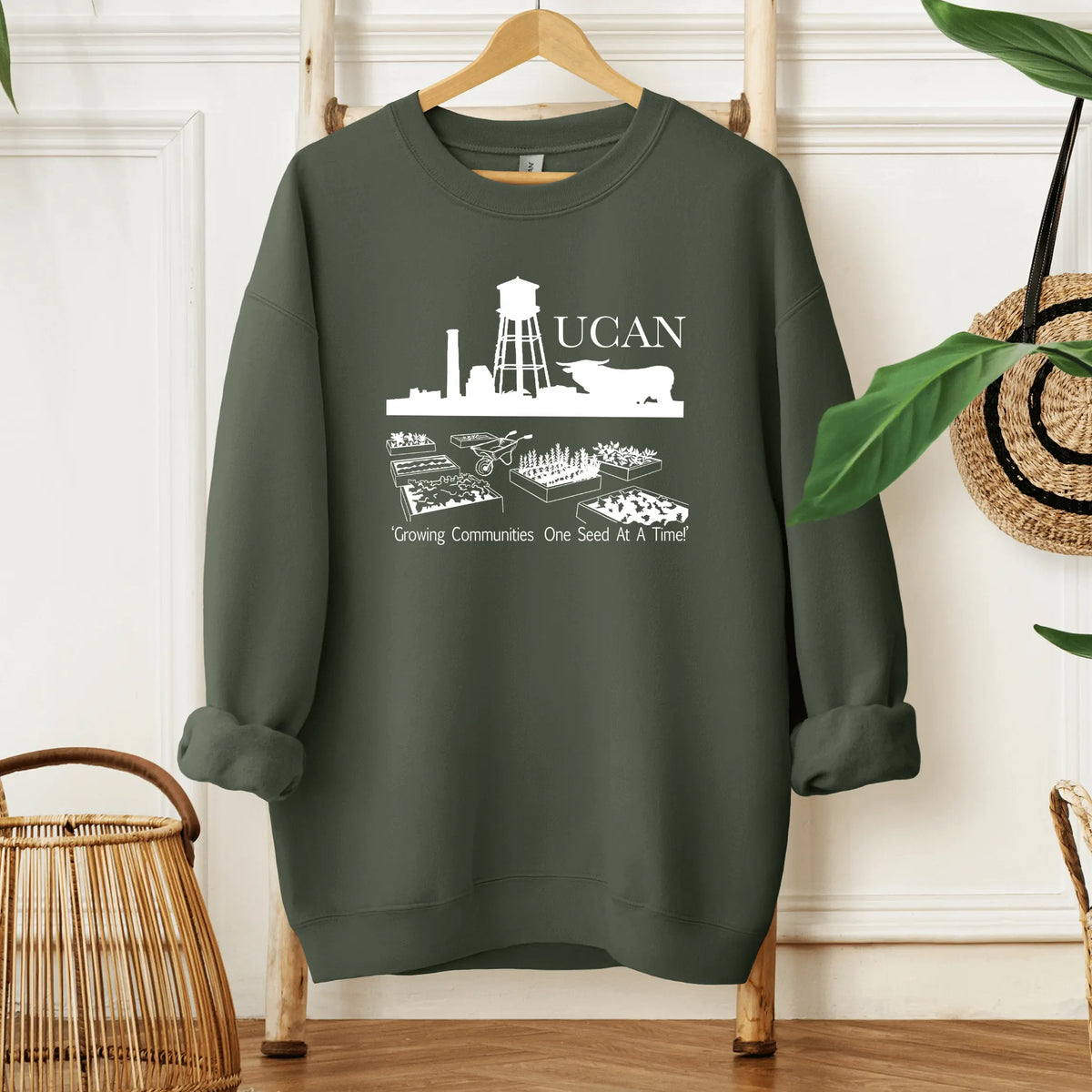 Brown UCAN crewneck sweatshirt by Winks Design Studio, LLC, shown on a small-sized model with a comfortable fit.