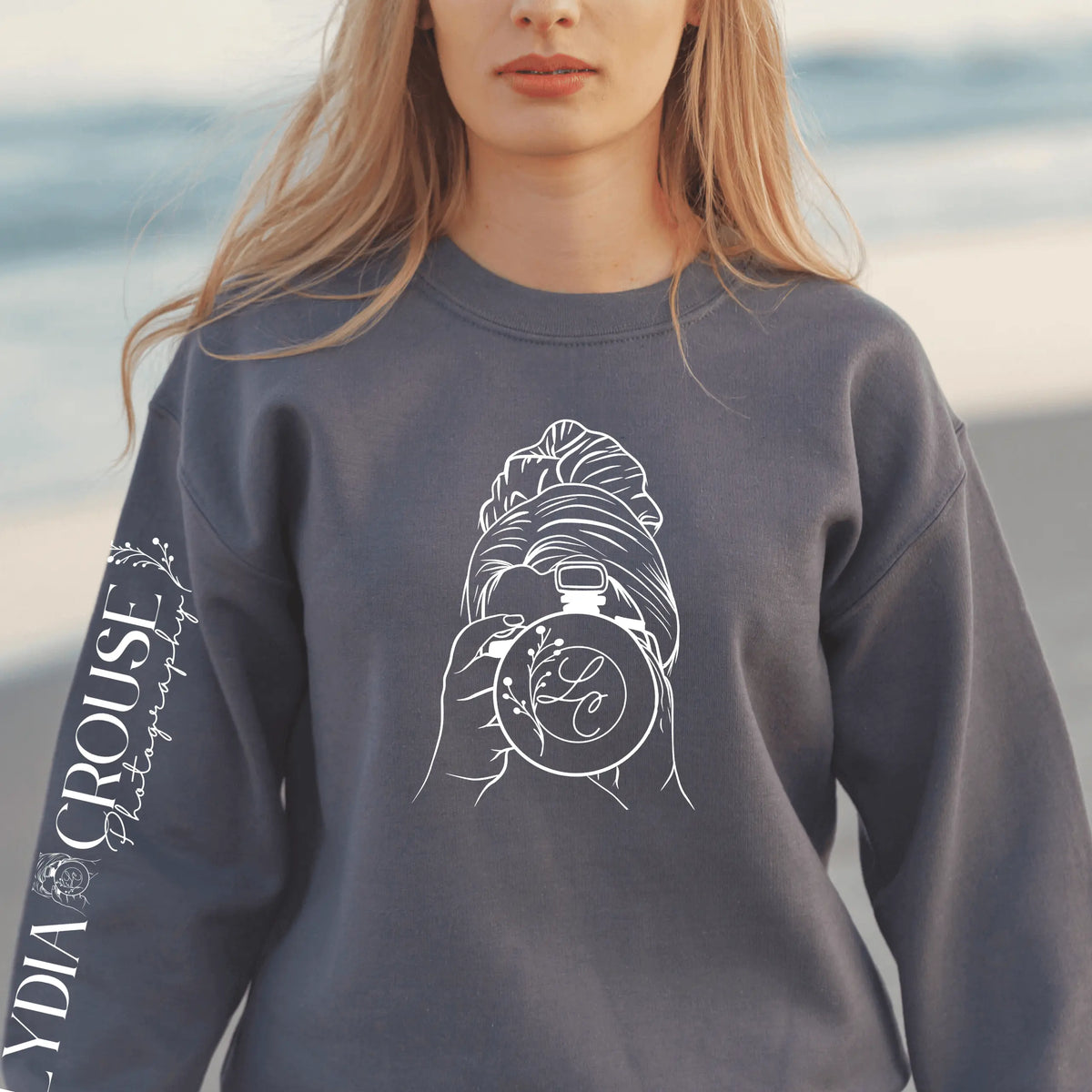 Pink Lydia Crouse crewneck sweatshirt by Winks Design Studio, LLC, displayed flat with visible neckline and fabric texture.