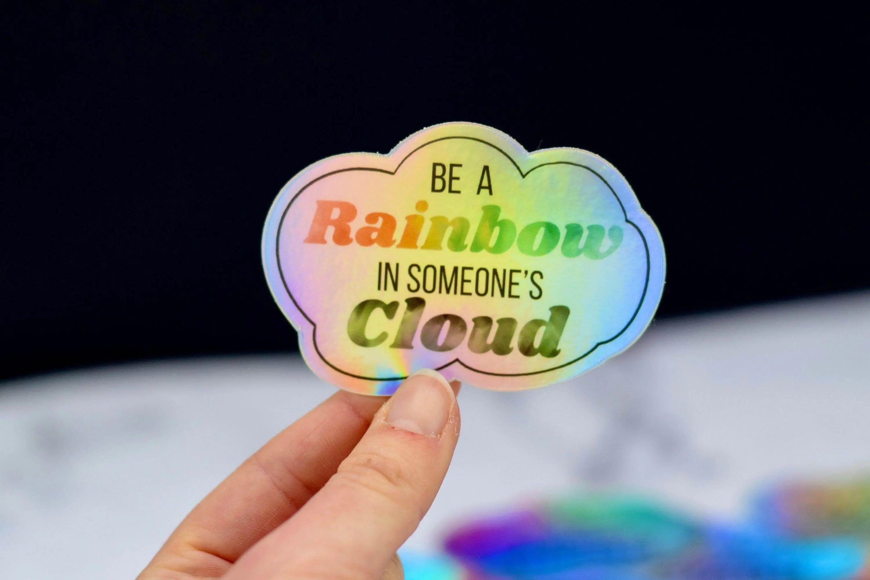 Decorative sticker featuring a rainbow and cloud design by Winks Design Studio, LLC, perfect for decorating notebooks or laptops.