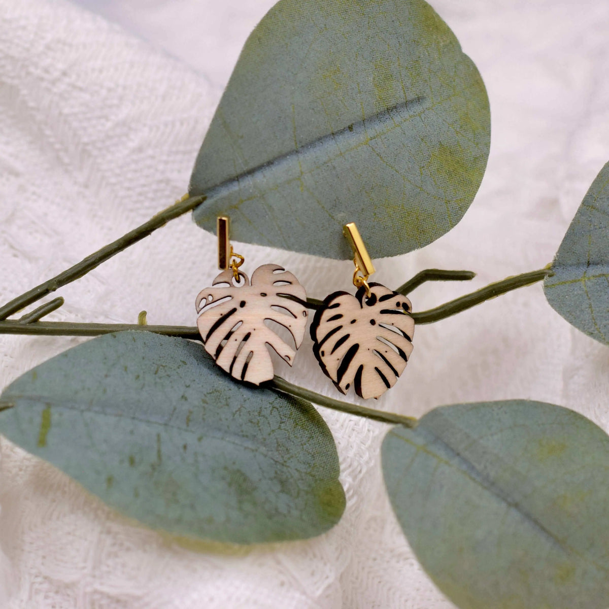 Wooden Monstera leaf earrings by Winks Design Studio, LLC, featuring natural wood texture and tropical leaf design.