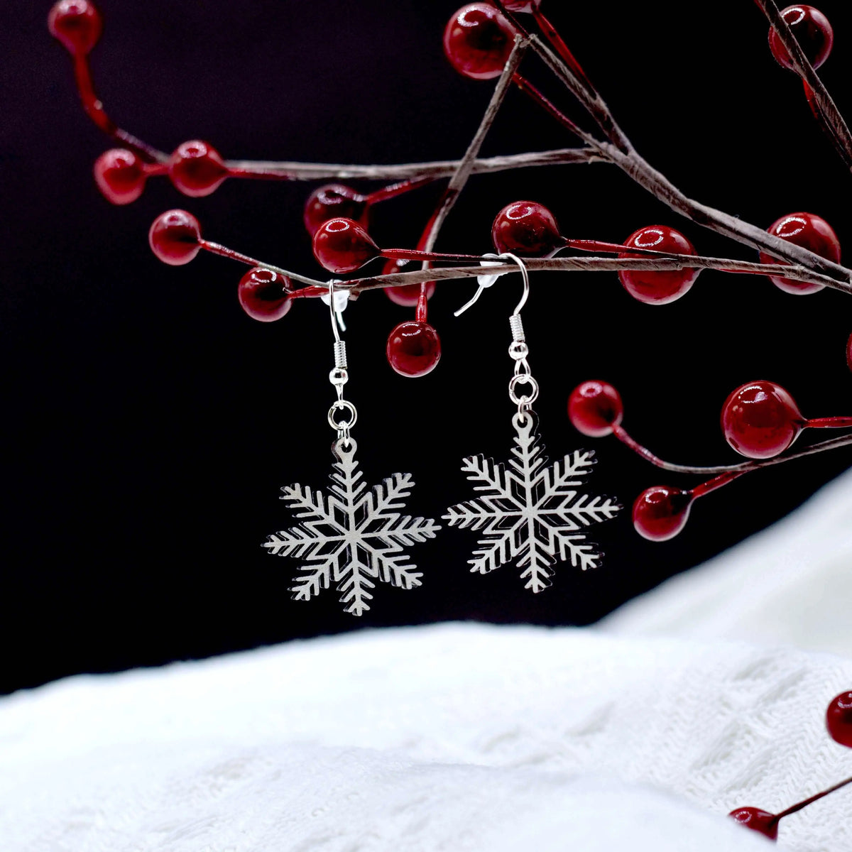 Wooden shimmering snowflake earrings by Winks Design Studio, LLC featuring detailed snowflake design and natural wood finish.