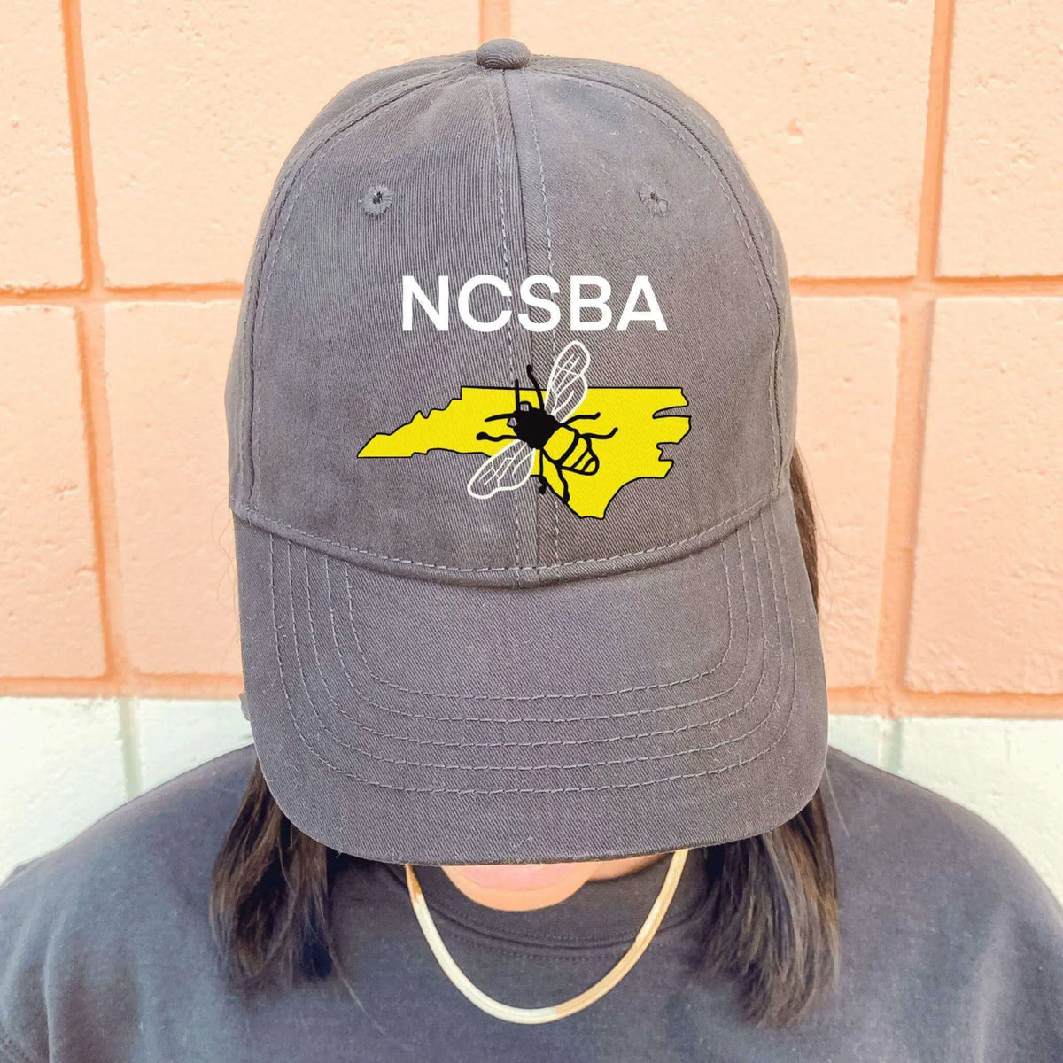 Black custom logo hat by Winks Design Studio, LLC, featuring a stylish design and adjustable strap.