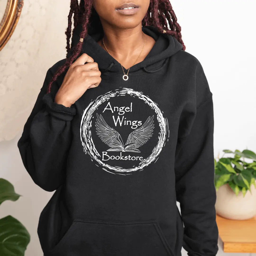 Pink hoodie by Winks Design Studio with angel wings and bookstore circular design, casual and cozy apparel.