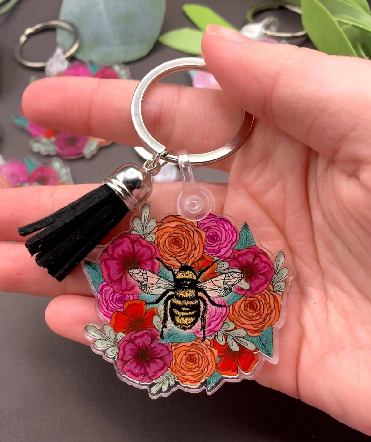 Bee and flowers themed keychain by Winks Design Studio, LLC, featuring a detailed bee charm surrounded by colorful floral designs.