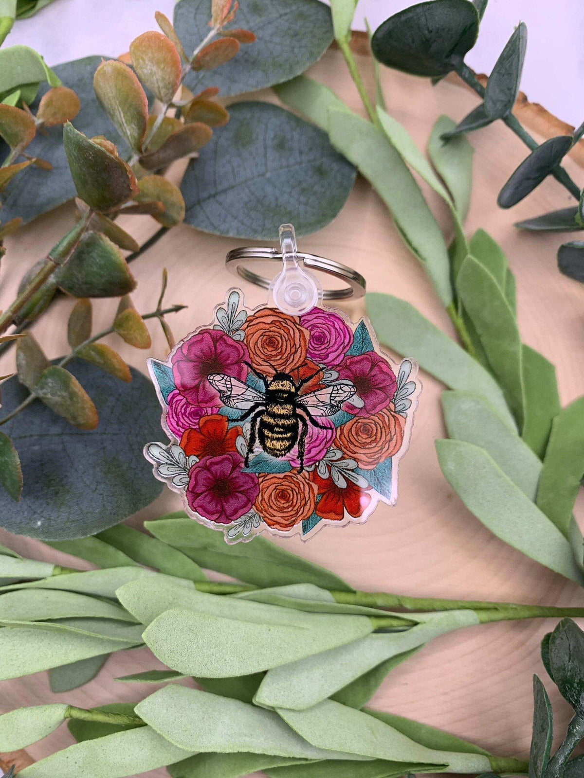 Winks Design Studio LLC bee and flowers keychain with detailed bee and floral design on a metal keyring.