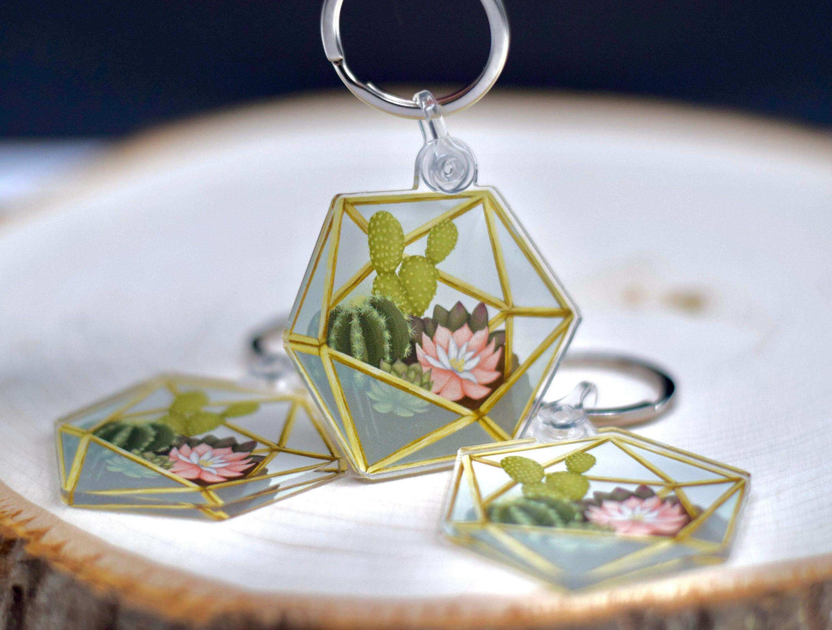 Acrylic succulent terrarium keychain featuring a detailed miniature plant design from Winks Design Studio, LLC.