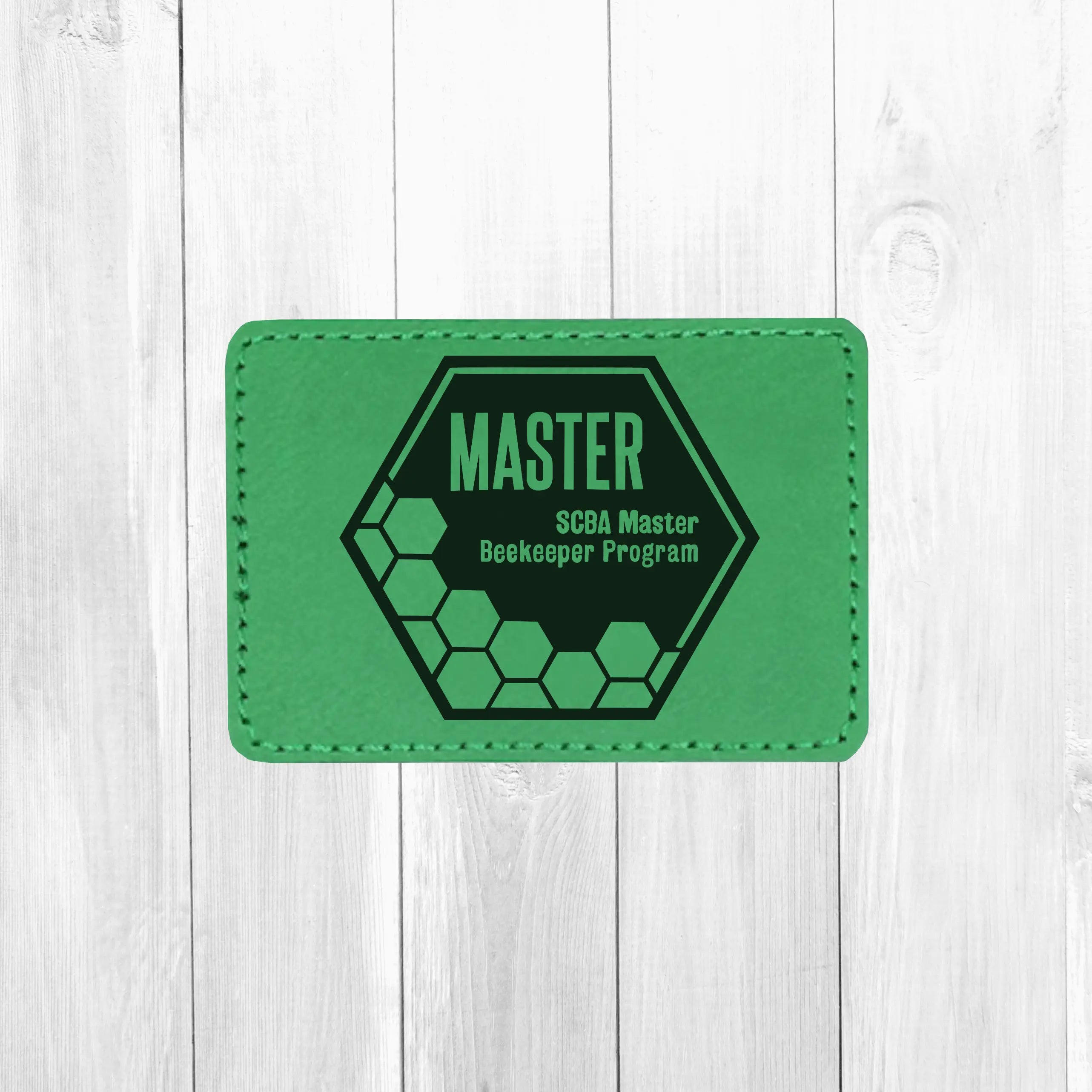 Leather patch featuring SCBA Master Program design by Winks Design Studio, LLC, showcasing detailed craftsmanship and branding.