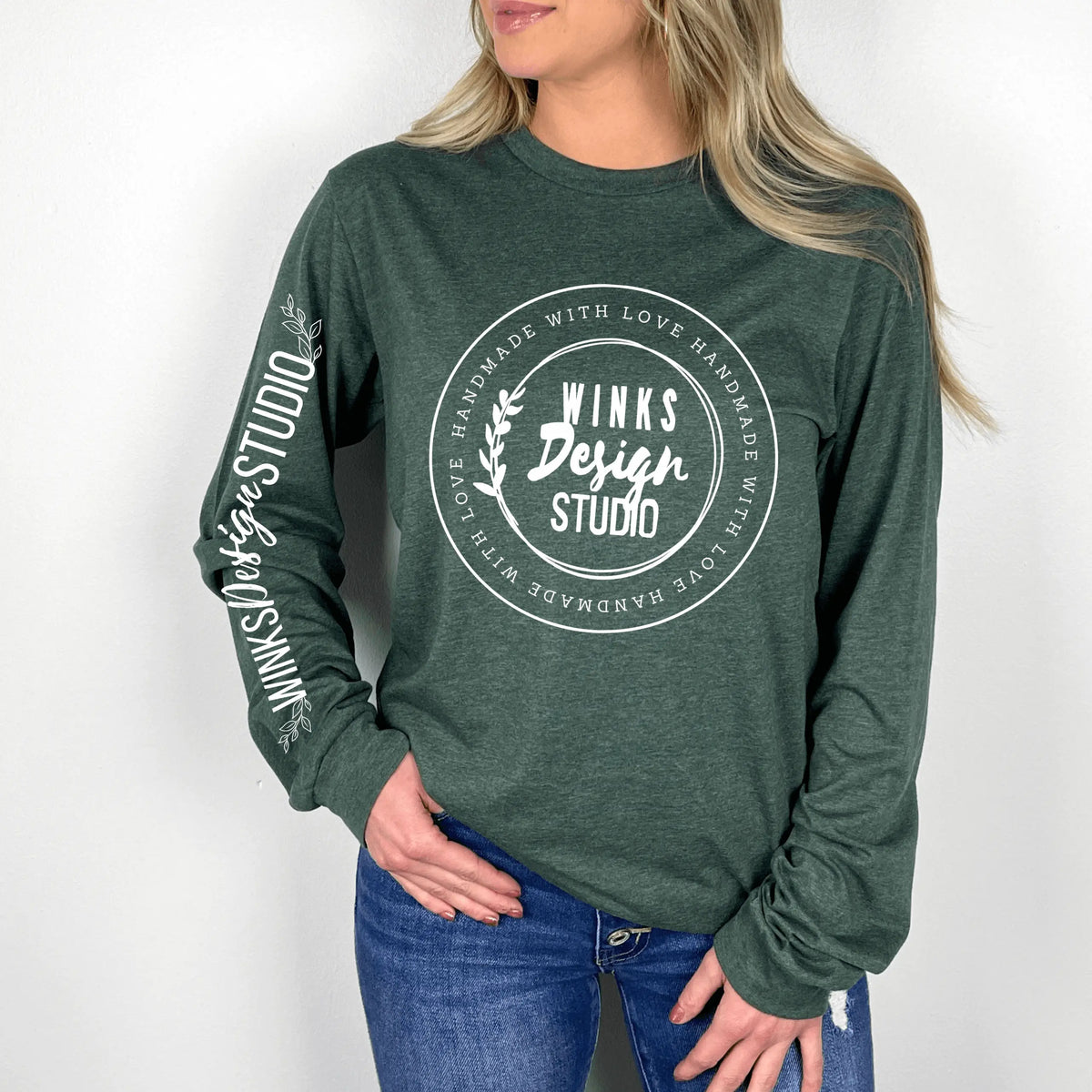 Forest green Winks Design Studio WDS logo long sleeve shirt, featuring a small logo on the front.