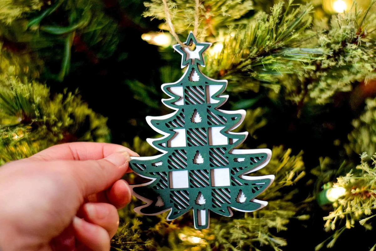 Plaid Christmas Tree Ornament by Winks Design Studio, LLC featuring festive red and green plaid fabric with a decorative loop for hanging.