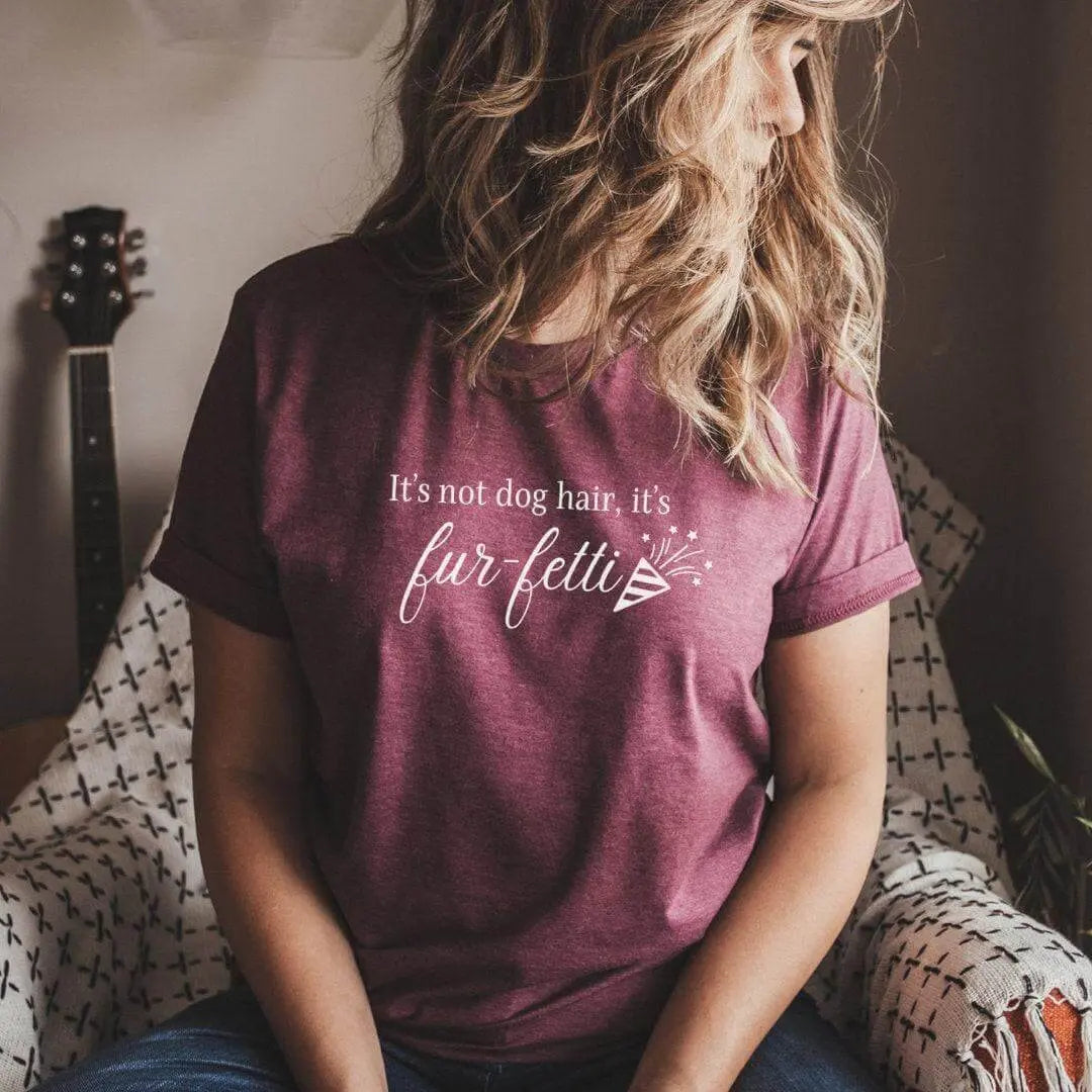 Black T-shirt from Winks Design Studio LLC featuring humorous "It’s Not Dog Hair, It’s Fur-fetti" print.