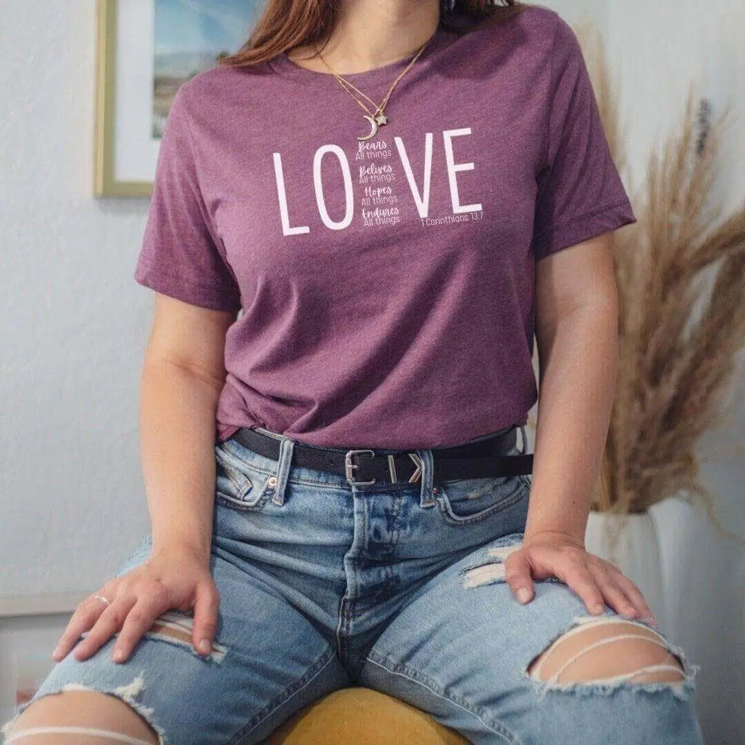 Maroon Love 1 Corinthians 13:7 Bible verse T-shirt by Winks Design Studio, LLC, featuring a small design and comfortable fit.