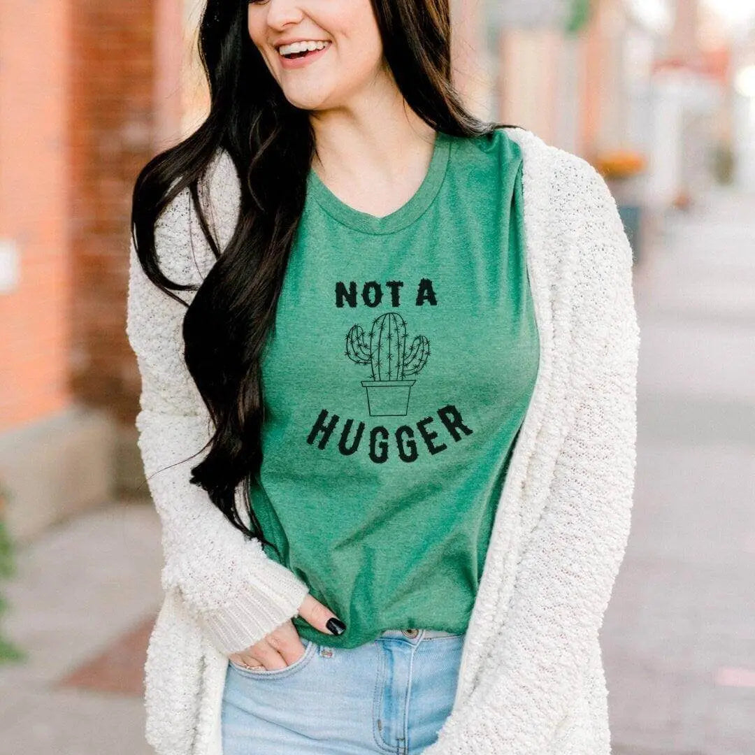 Mint green Not A Hugger funny cactus T-shirt by Winks Design Studio, LLC, featuring a playful cactus graphic on the front.