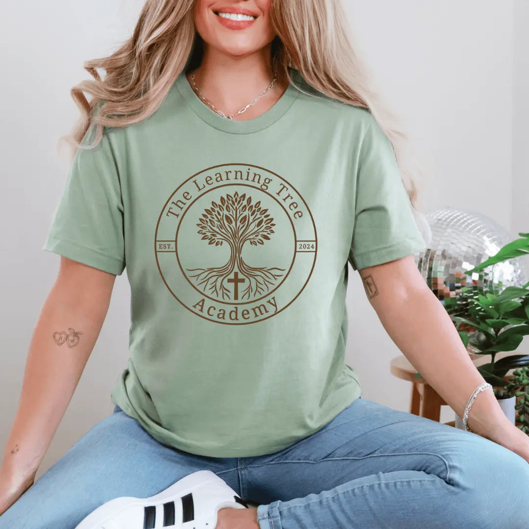 Small brown T-shirt from Winks Design Studio featuring The Learning Tree Academy logo and design on the front.