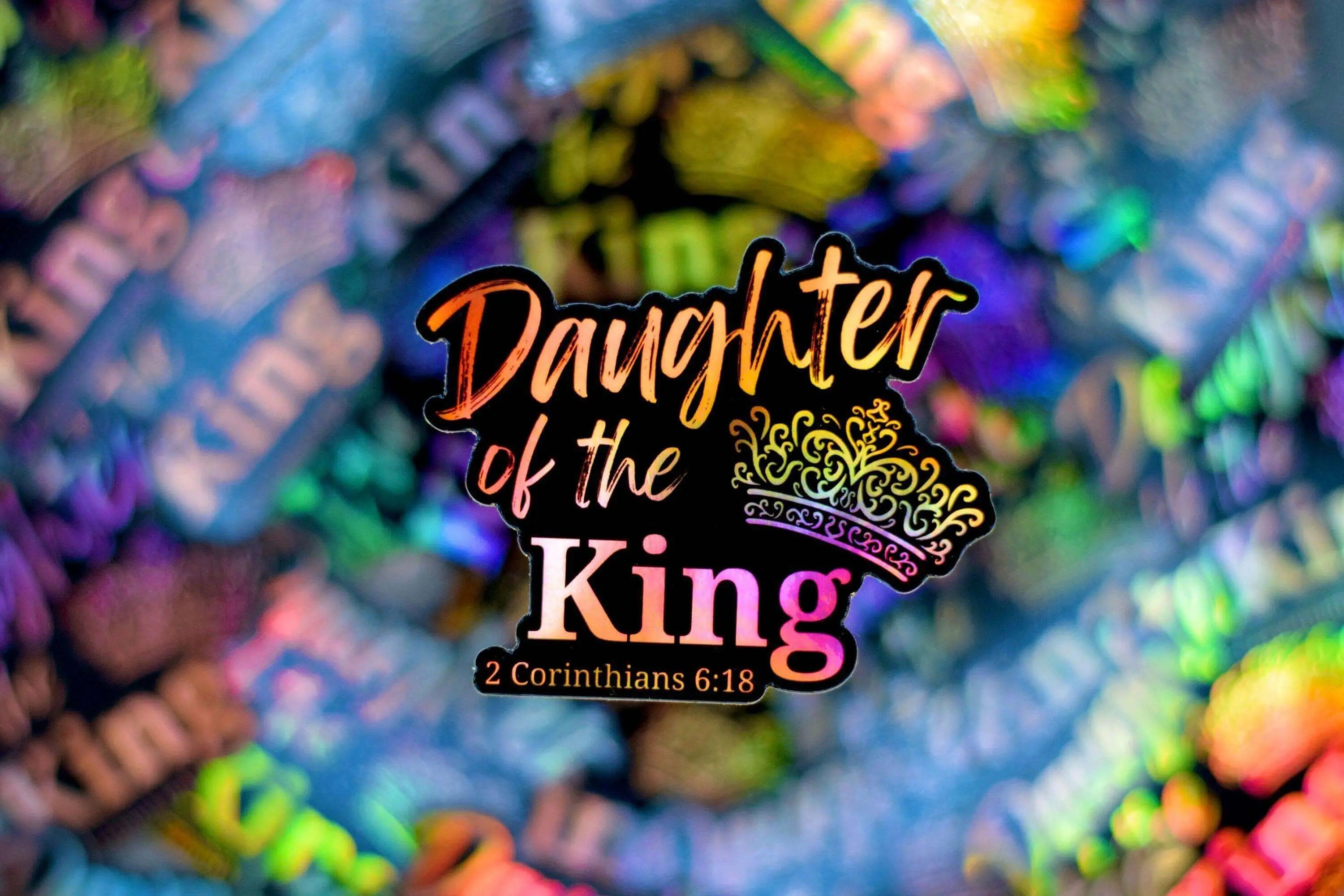 Vinyl sticker featuring the phrase "Daughter of The King" by Winks Design Studio, LLC, with elegant lettering and decorative details.