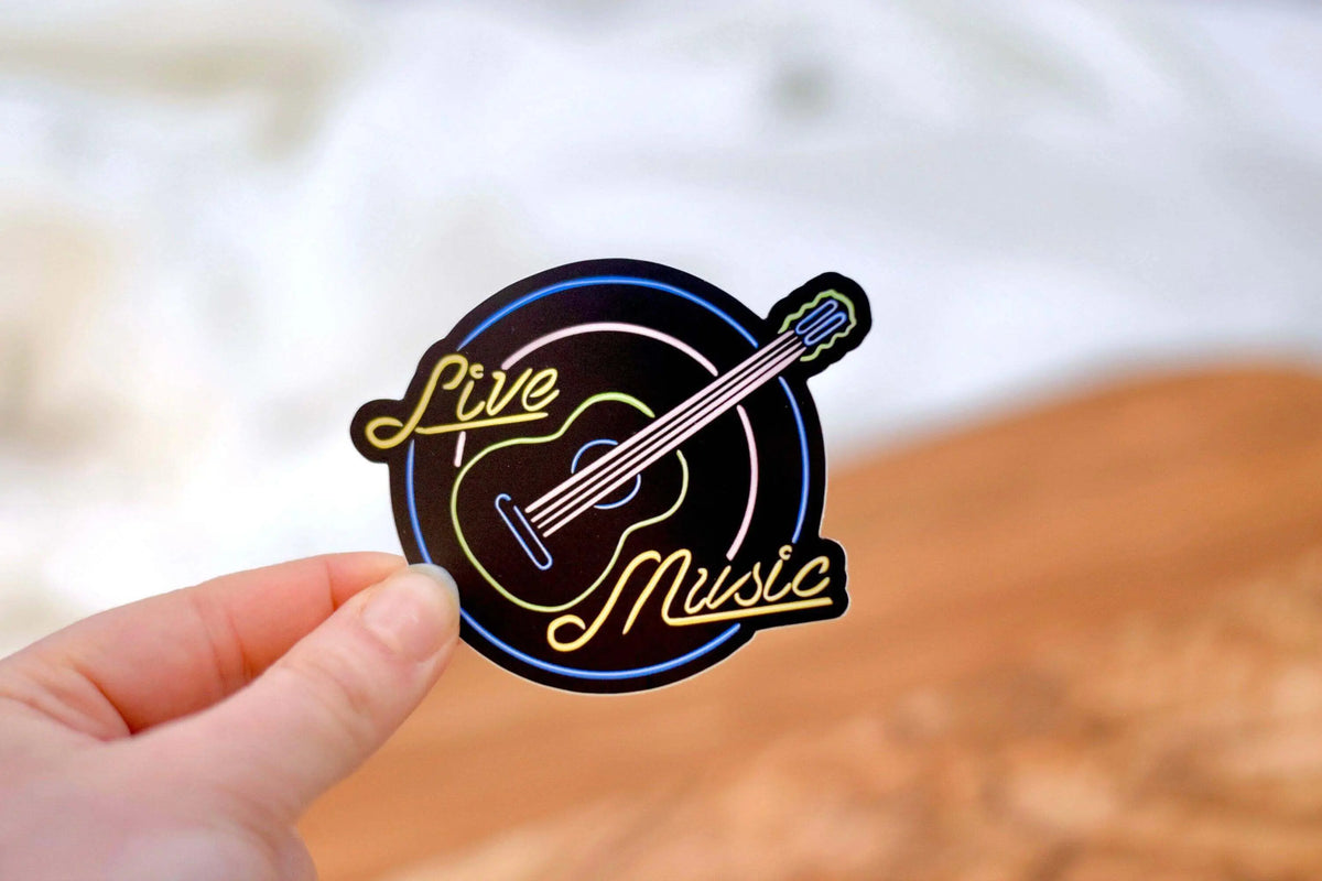 Live music neon sign waterproof vinyl sticker by Winks Design Studio, LLC, 3x2.5 inches, featuring vibrant neon music design.