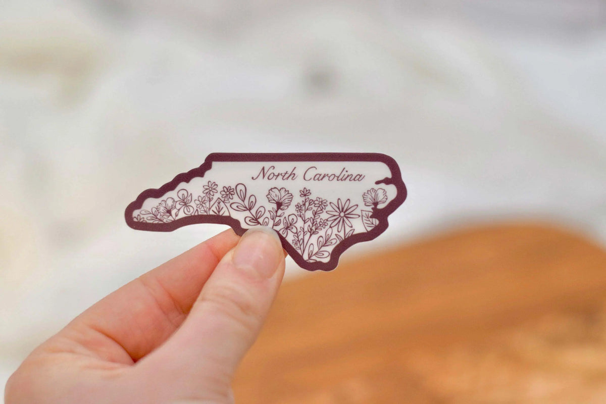 Mini North Carolina Wildflower vinyl sticker by Winks Design Studio, LLC, featuring colorful wildflower design on a clear background.