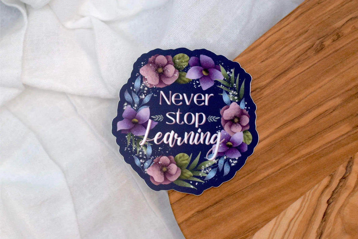 Vinyl sticker from Winks Design Studio featuring the phrase "Never Stop Learning" in black text on a 2x2 inch background.
