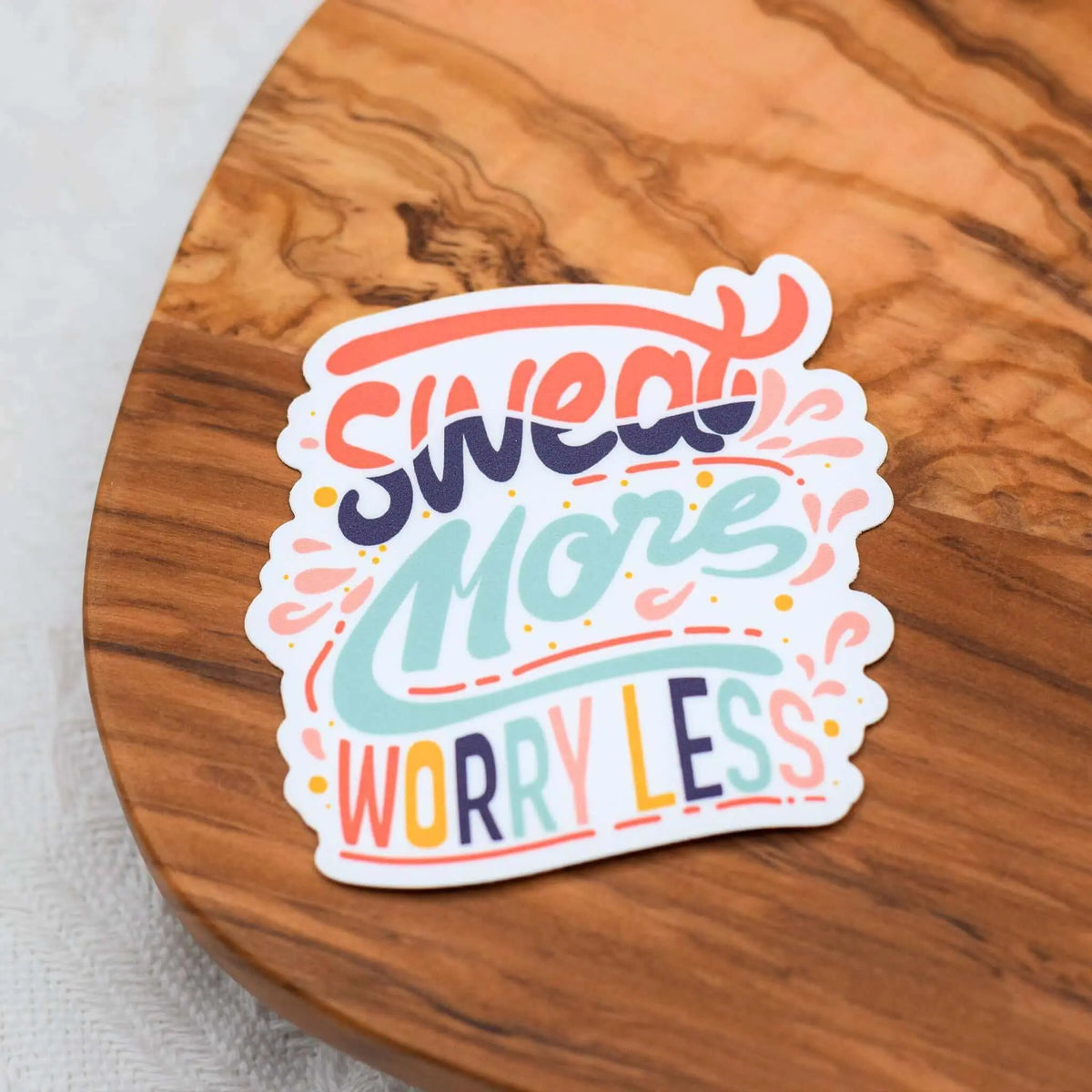 Vinyl sticker featuring the "Sweat More Worry Less" motivational quote, designed by Winks Design Studio LLC.