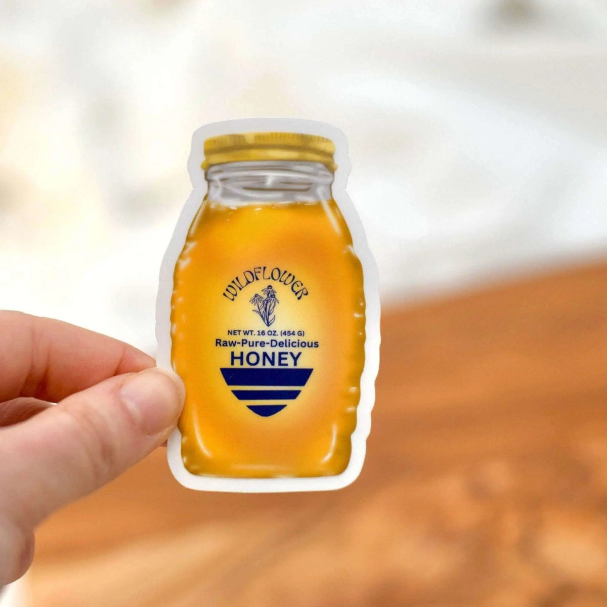 Vinyl sticker of a wildflower honey jar design from Winks Design Studio, LLC, featuring colorful flower and honey imagery.